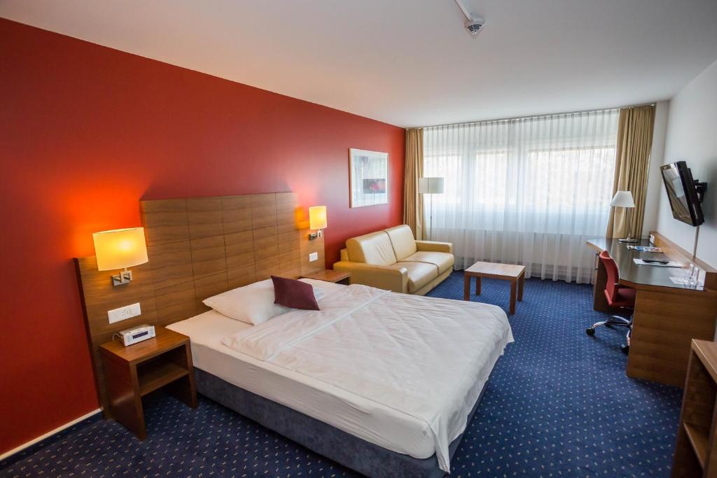 um quarto de hotel com uma cama e uma cadeira em Hotel Höri Inn em Höri