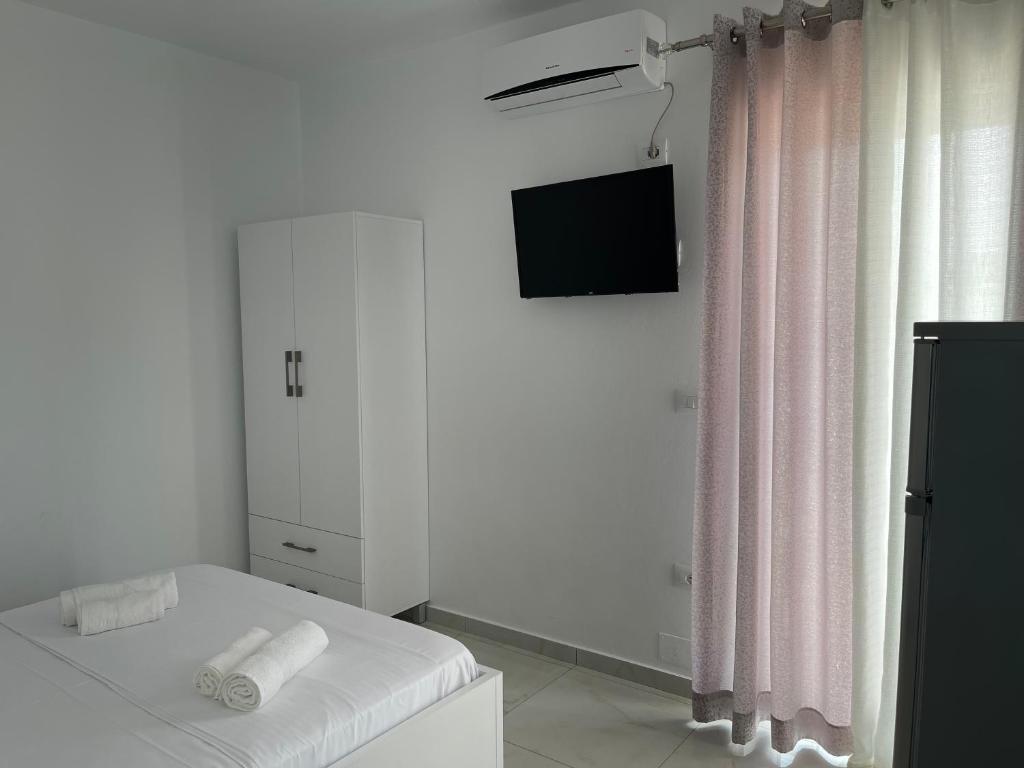 a white room with a bed and a television at Villa Angelina Ksamil in Ksamil