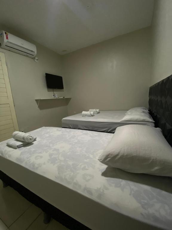 1 dormitorio con 2 camas y toallas. en FlatStudio04 em condomínio residencial na Nova Betânia, en Mossoró
