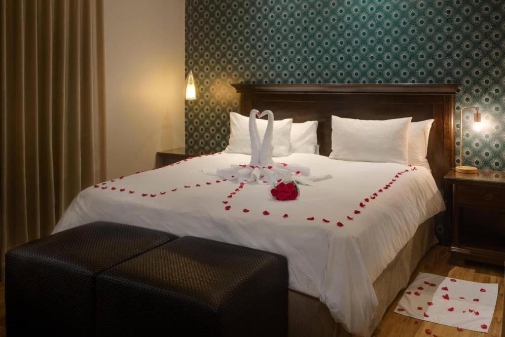 a hotel room with a bed with red roses on it at MOONLIGHT HOLIDAY HOME in Durban