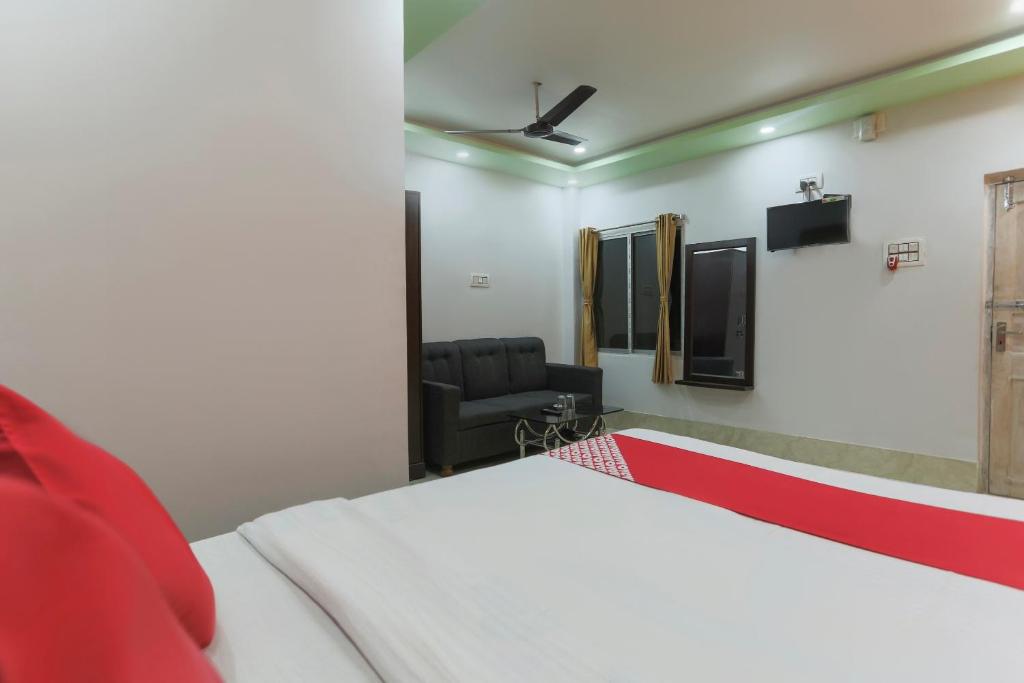 BaharampurにあるOYO Flagship 67063 Roy Villa Resortのベッドルーム1室(ベッド1台、椅子1脚付)