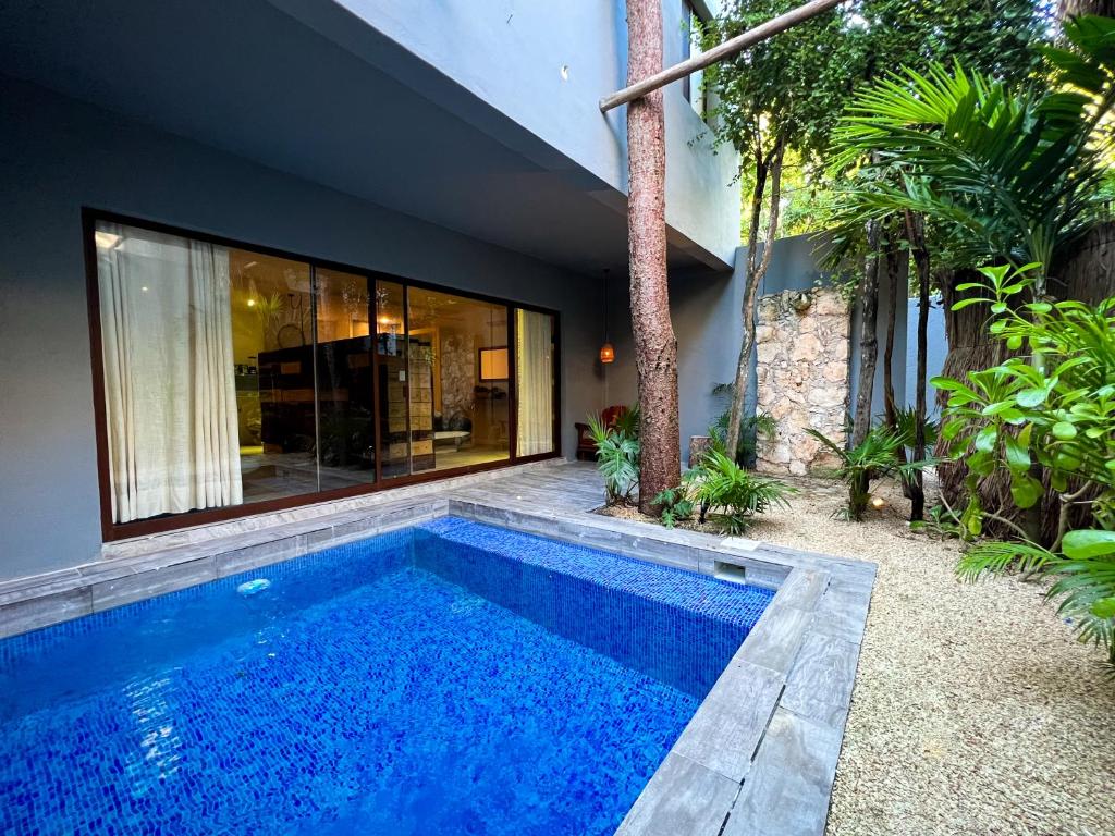a swimming pool in front of a house at Kuun Taak Tulum in Tulum