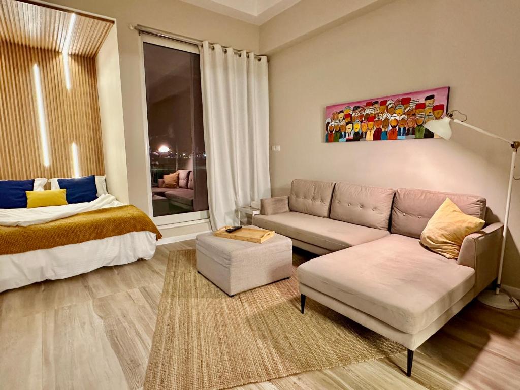 uma sala de estar com um sofá e uma cama em Silicon Path Spacious studio no Dubai