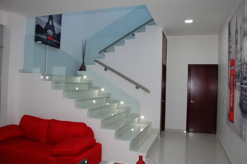 La Barca的住宿－Hotel Cermar Plaza，客厅里设有红色沙发的楼梯