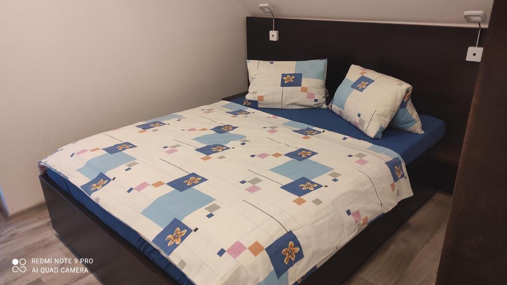 a bed with a quilt on it in a bedroom at Apartmán na Šumavě in Vimperk