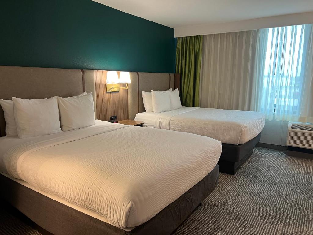 Cette chambre comprend 2 lits et un mur vert. dans l'établissement Clarion Hotel Nashville Downtown - Stadium, à Nashville
