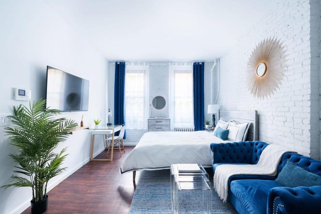 1 dormitorio con 1 cama y 1 sofá azul en 83-2FE UES Central Park Newly Furnished Studio en Nueva York