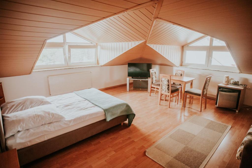 Un dormitorio con una cama y una mesa y sillas. en Wiking, en Jastrzębia Góra