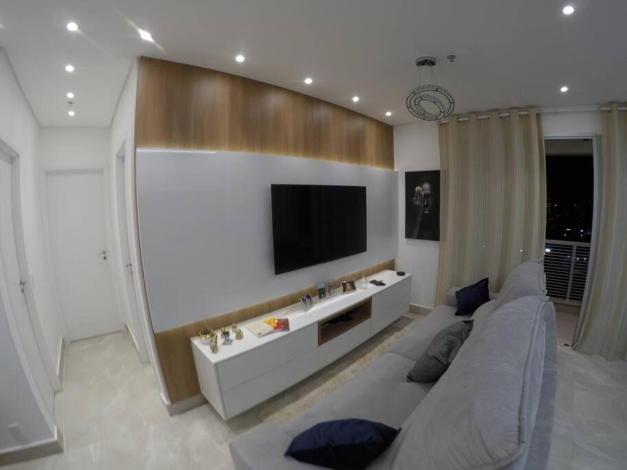ein Wohnzimmer mit einem Sofa und einem Flachbild-TV in der Unterkunft Apartamento inteiro aconchegante, ótima localização! in Osasco