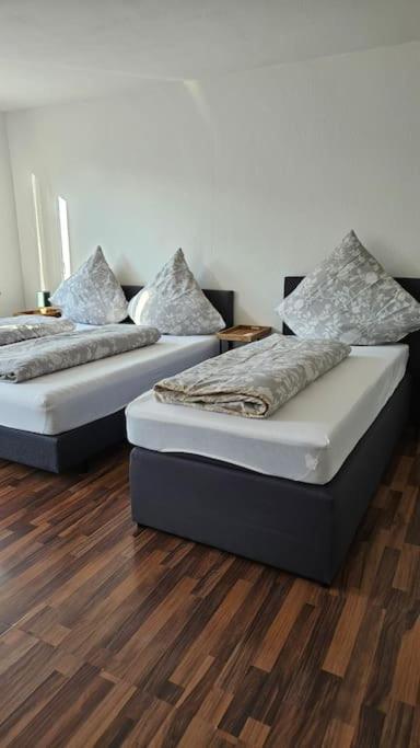 twee bedden in een kamer met houten vloeren bij City Apartment Kehl in Kehl am Rhein