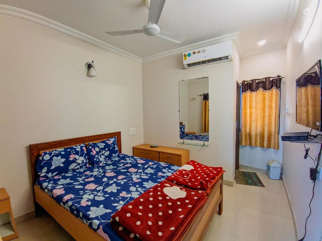 1 dormitorio con cama y espejo en HK Inn, en Mandvi