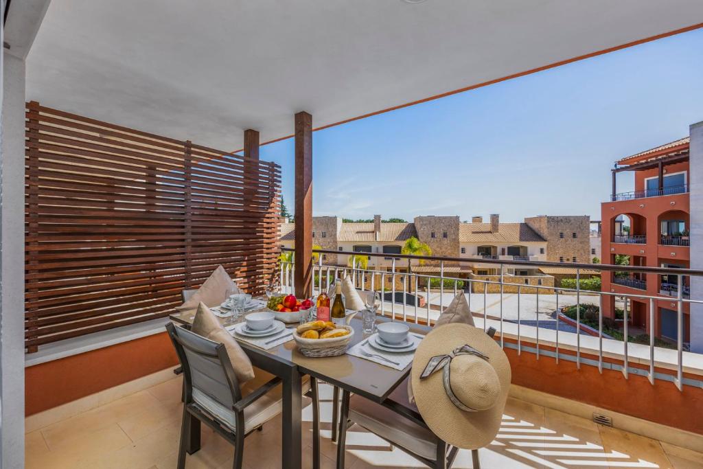 a table and chairs on a balcony with a view at Pine Garden Apartment Vilamoura in Vilamoura