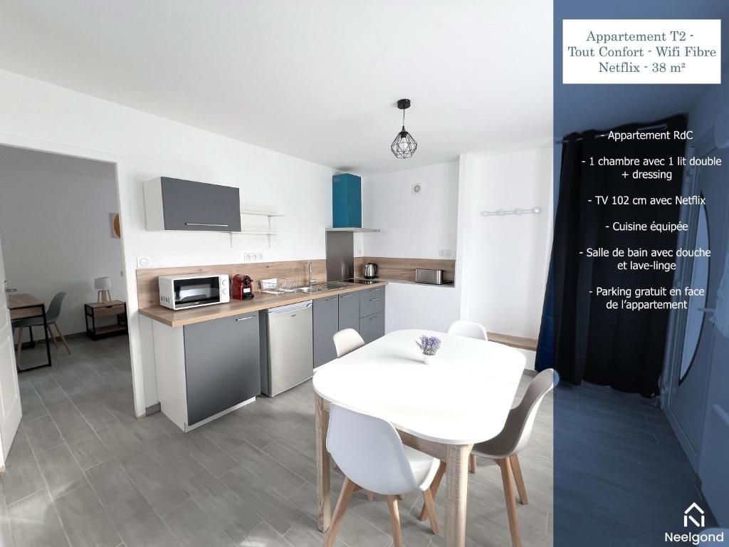 cocina con mesa blanca y sillas blancas en 178B - Appartement T2 Tout Confort - Wifi Netflix, en Le Gond-Pontouvre