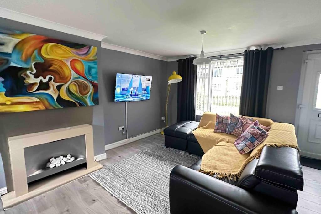 a living room with a couch and a fireplace at King Or Twin Bed In Stylish Home in Nottingham