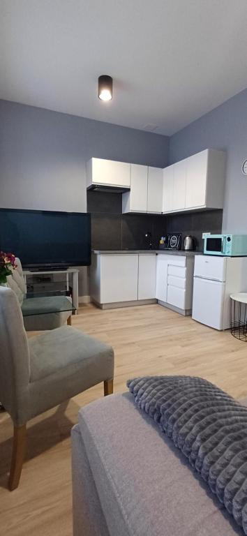 チェンストホヴァにあるKawalerka Centrum parking prywatnyのキッチン(ソファ、椅子付)