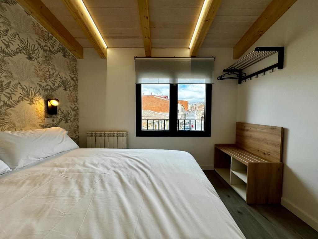 a bedroom with a white bed and a window at Apartamentos centro I.II in El Barraco
