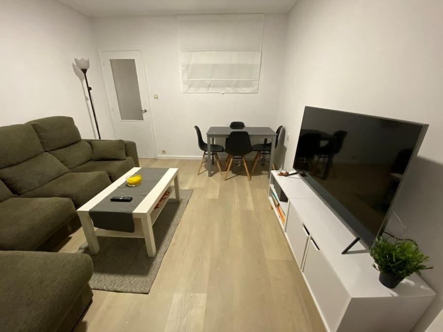 ein Wohnzimmer mit einem Sofa und einem Tisch in der Unterkunft Piso en el corazón de A Coruña. in A Coruña