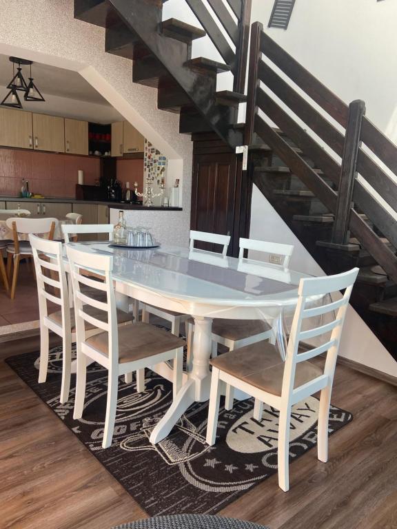 a dining room with a table and chairs at Casa Cataleya in Bucşoaia