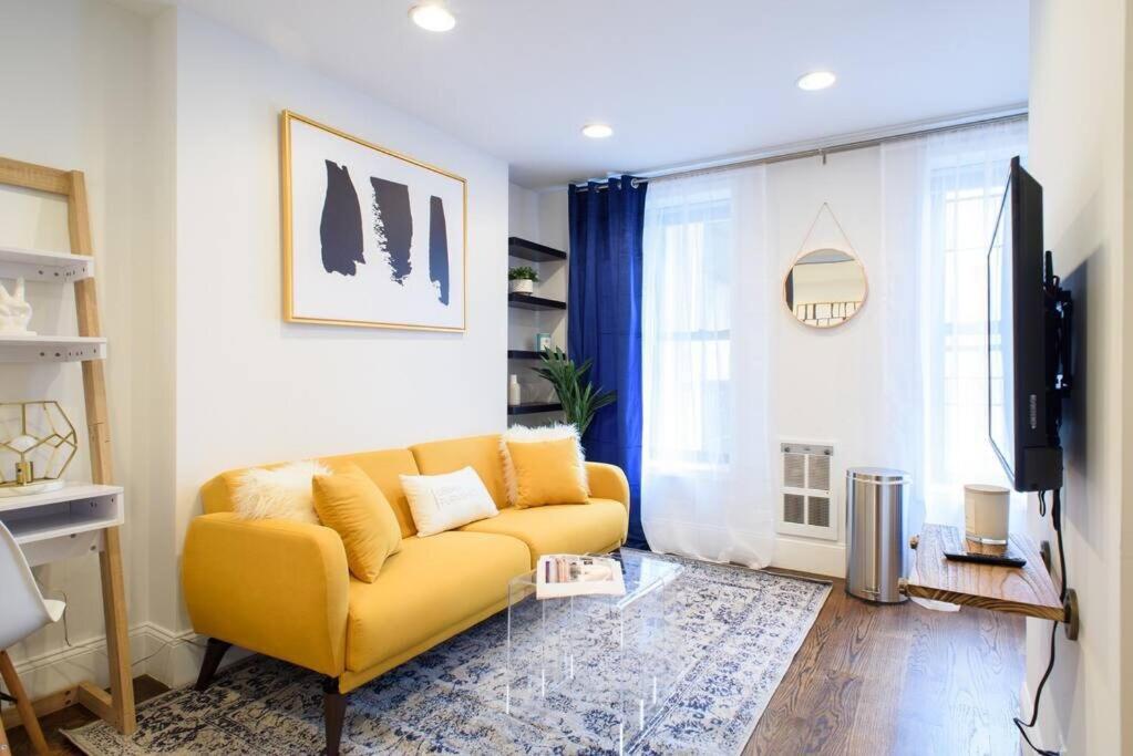a living room with a yellow couch and a television at 69-4A Quality NEW Prime Lower East East 1br Apt in New York