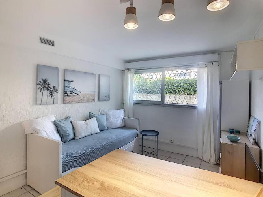 un salon avec un canapé et une fenêtre dans l'établissement GOLFE JUAN Studio dans résidence avec piscine, à Vallauris