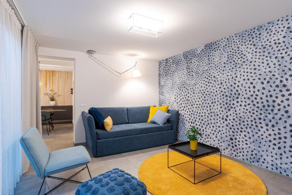 uma sala de estar com um sofá azul e uma mesa em MarAvilia Apartment, vicino al Monte Tamaro e al parco acquatico Splash & SPA em Monte Ceneri