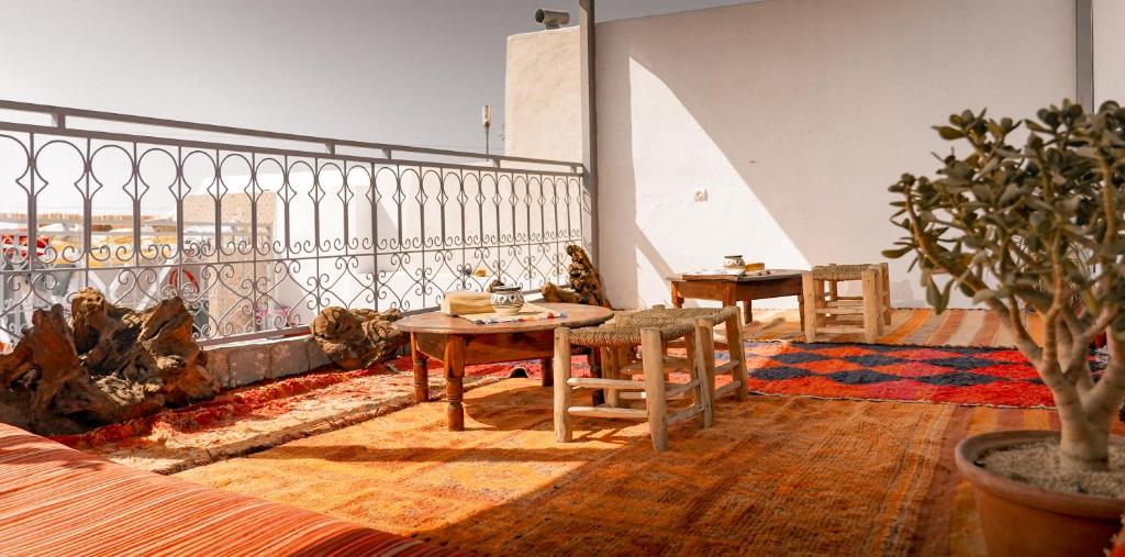 a room with two tables and chairs on a balcony at Soul Surf House in Agadir
