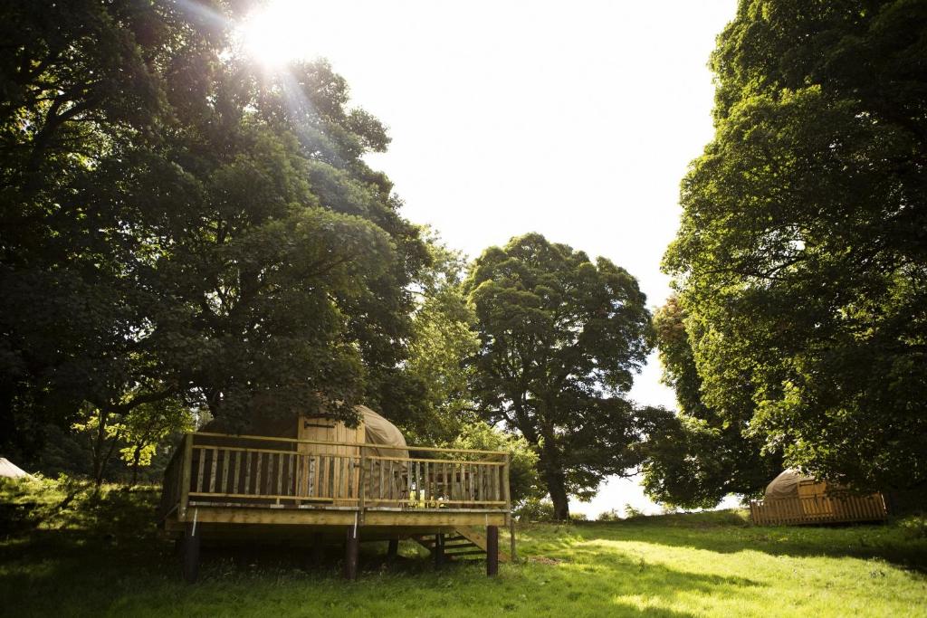 a park bench sitting in the grass in a field at Rock Farm Slane - Glamping in Slane