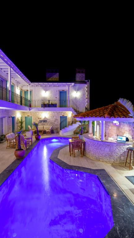 a swimming pool at night with purple lights at Avlu Alaçatı Boutique Hotel in Alaçatı