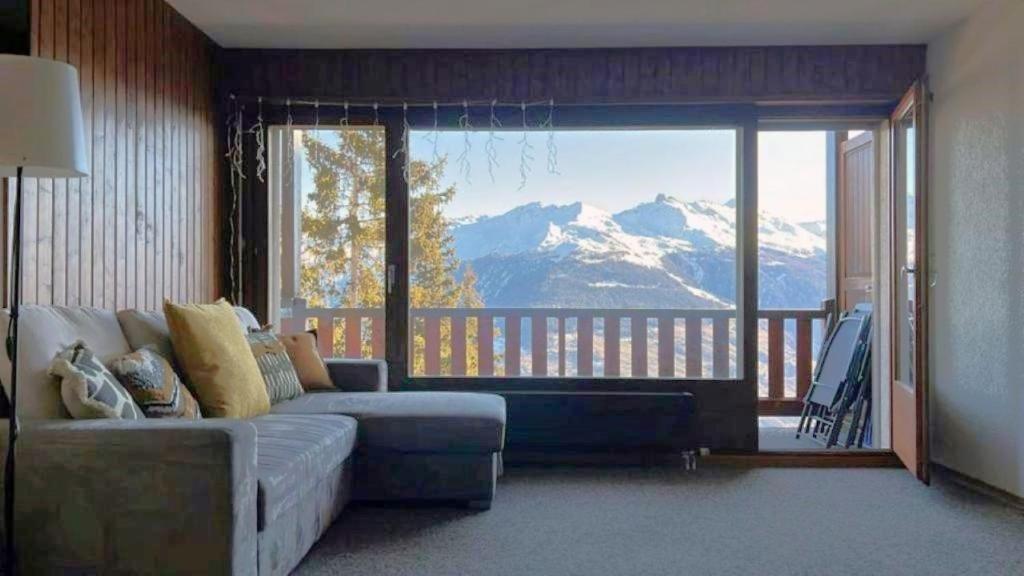 a living room with a couch and a view of a mountain at Cosy studio for 4 near ski lift, HAMEAU C13 in Les Collons