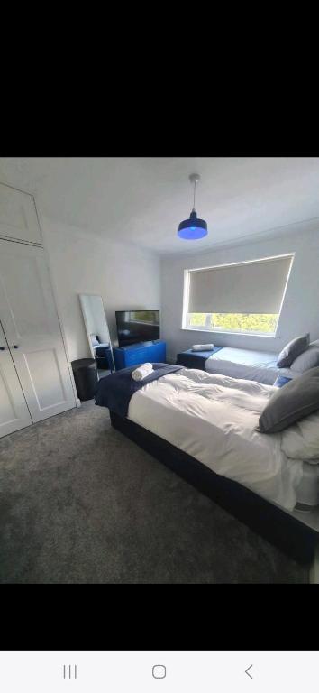 盧頓的住宿－Lovely 3 bedroom house free parking，一间卧室设有一张大床和一个窗户。