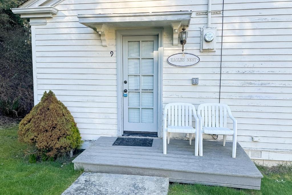 dos sillas blancas sentadas en el porche de una casa en Cottage 9 - The Eagle's Nest en Coupeville