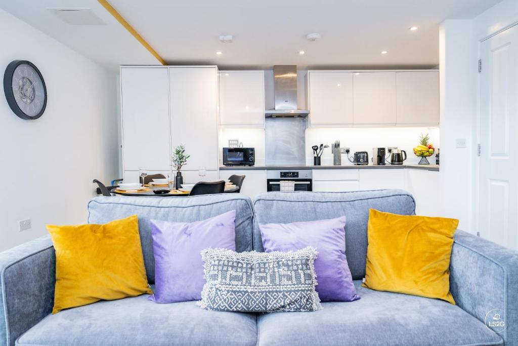a blue couch with purple and yellow pillows in a kitchen at Comfy & spacious Apt, 2 balconies, near the 02 arena, Greenwich in London