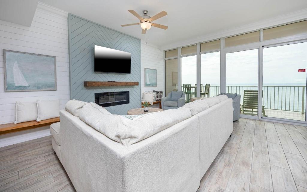 a living room with a white couch and a tv at Phoenix Orange Beach II 2003 in Orange Beach