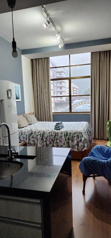 una camera con due letti e un tavolo e una finestra di Loft no Alto a Teresópolis