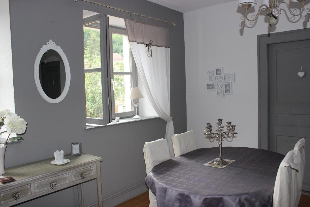 里博維萊的住宿－Gite Des 3 Chateaux，一间带桌子和镜子的用餐室