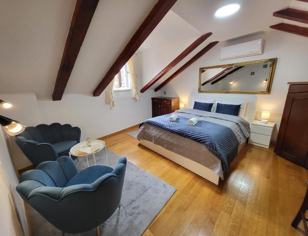 ドゥブロヴニクにあるGreen Exclusive Apartmentsのベッドルーム1室(キングサイズベッド1台、椅子2脚付)