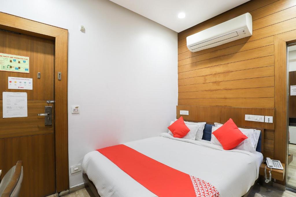 a hotel room with a bed with red pillows at Collection O Hotel Kyra in Ahmedabad