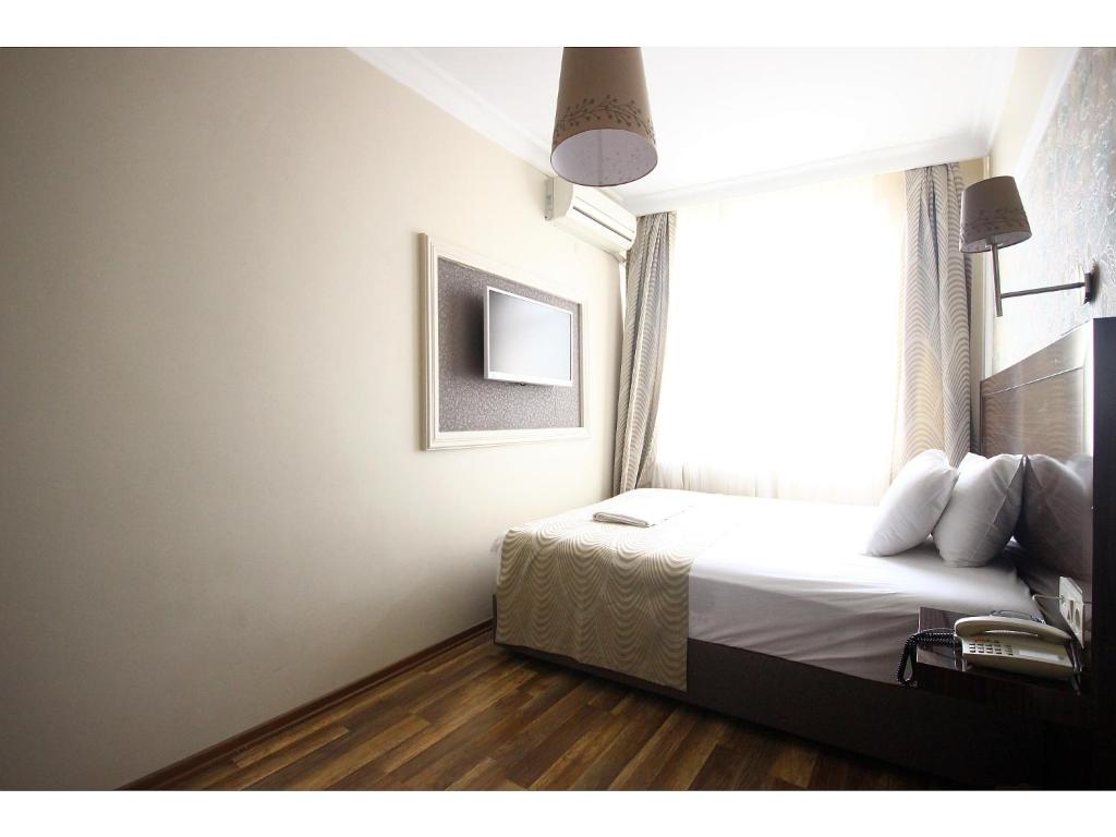 a bedroom with a bed and a window at Venus Hotel Taksim in Istanbul