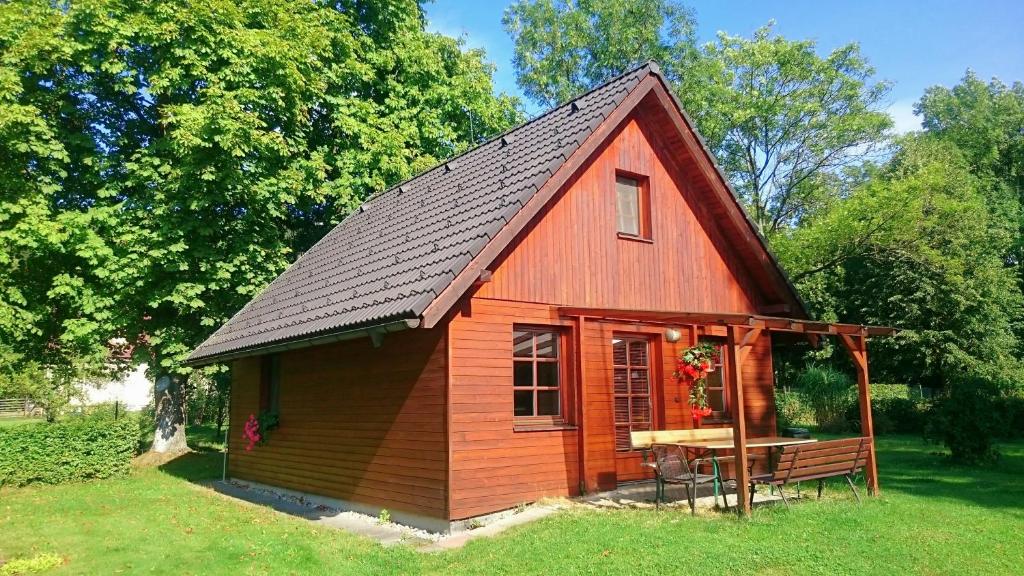 una pequeña casa roja con techo negro en A&B Bungalovy, en Morávka