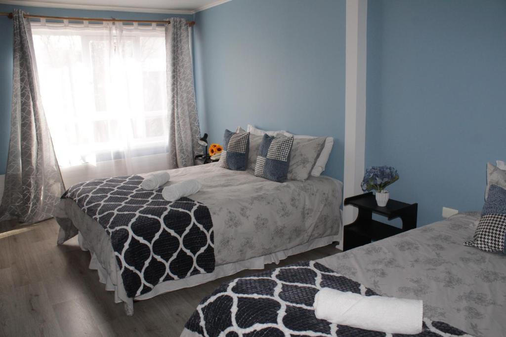 1 dormitorio con cama y ventana en HOTEL LOYOLA, en Coyhaique