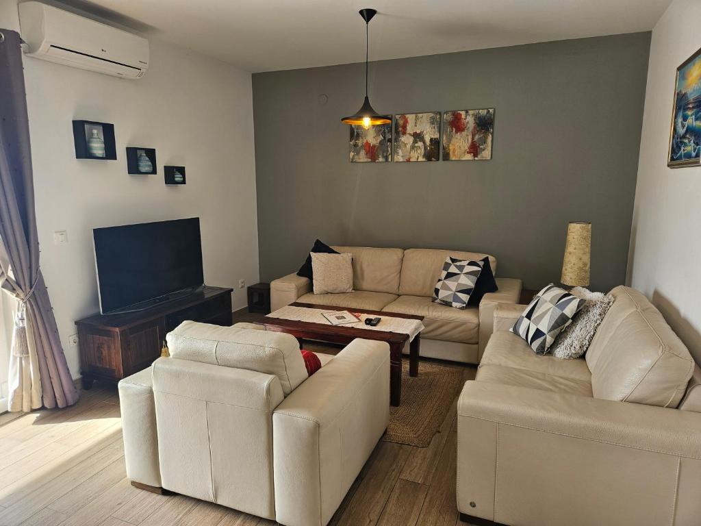 sala de estar con muebles blancos y TV de pantalla plana en Apartment Marbella, en Dubrovnik