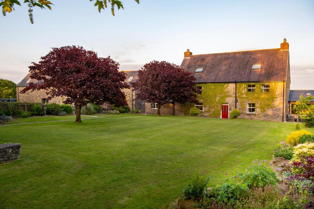 an old stone house with a large yard at Kidwelly Farmhouse B&B in Kidwelly