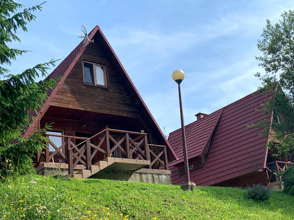 a large wooden house with a gambrel roof at Domki Bieszczady Siedlisko Harenda in Czarna