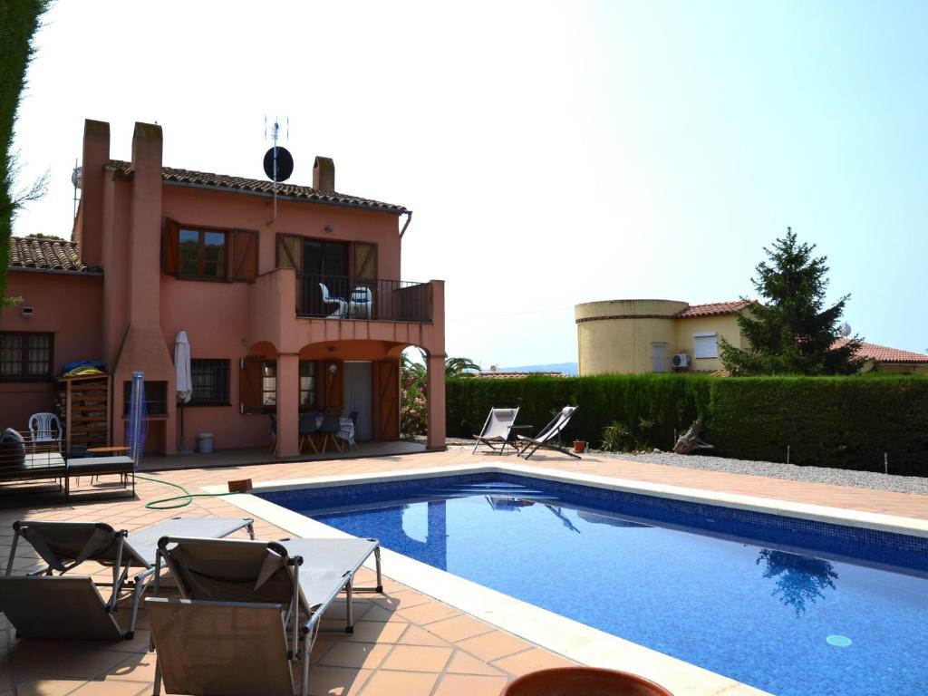 eine Villa mit einem Swimmingpool vor einem Haus in der Unterkunft Casa con Piscina Privada y Jardín Cerca de la Playa en L'Estartit - ES-323-6 in L'Estartit