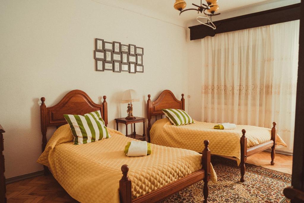 a bedroom with two beds with yellow and green pillows at Grandma's House in Penamacor