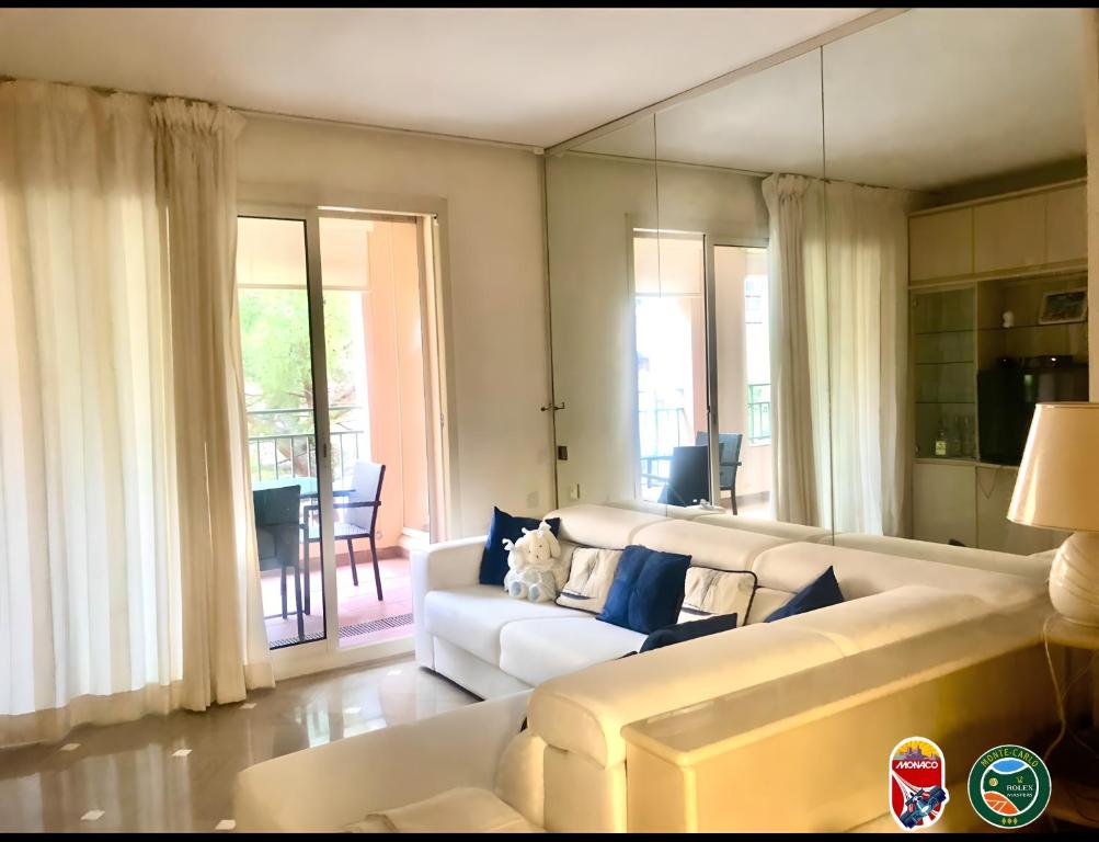 a living room with a white couch and a table at Monaco F1 Port de Fontvieille refined apartment overlooking the garden, with pool access, 10 min from GP in Monte Carlo