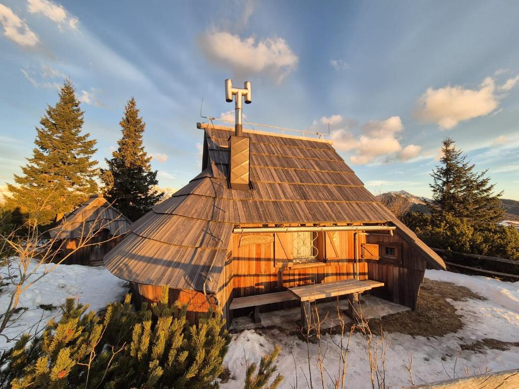 a small wooden church with a cross on the roof at Chalet-Koča Kamrica on Velika Planina in Stahovica