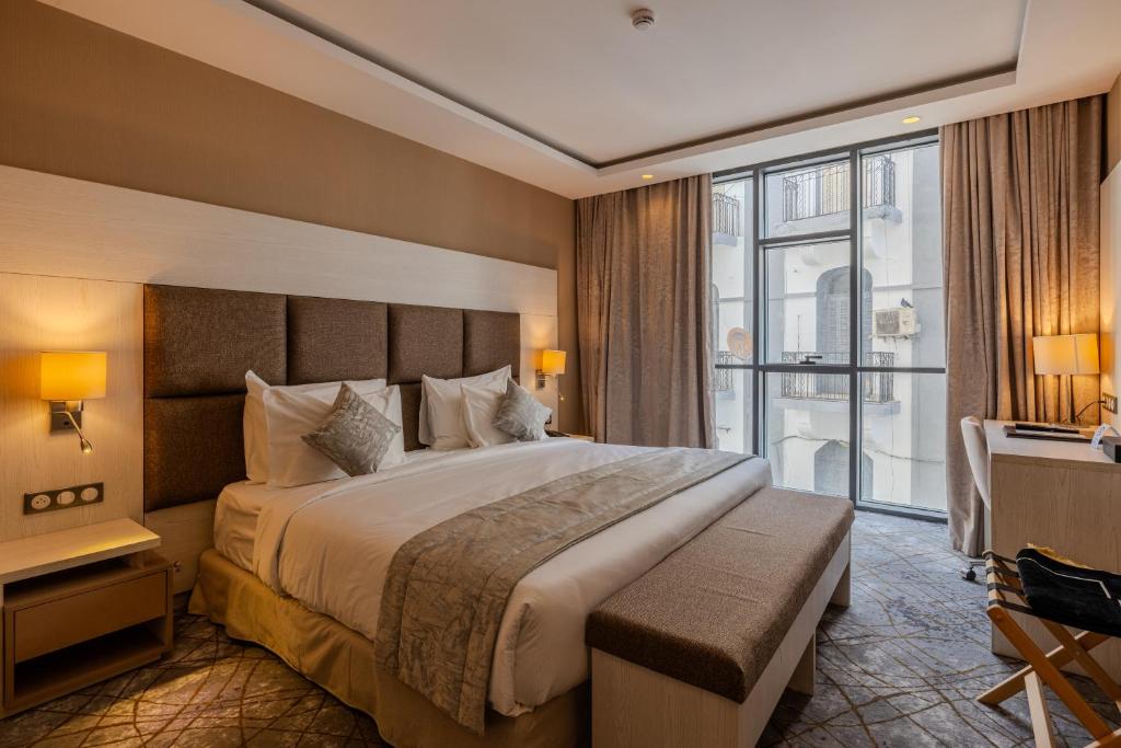 Habitación de hotel con cama grande y ventana en 2H Hotel en Orán