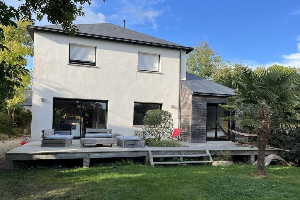 une maison avec deux chaises et une table devant elle dans l'établissement Villa au Coeur de la presqu'ile, à Crozon
