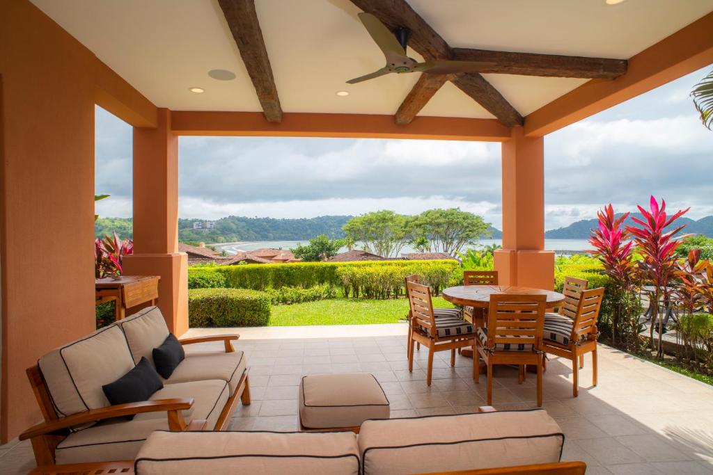 a screened porch with a table and chairs and a view at Los Suenos Resort Terrazas 1A in Herradura